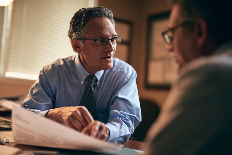 American advisor pointing at a consolidation payoff chart with a borrower
